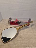 Front of cake server in box and reflective side of mirror