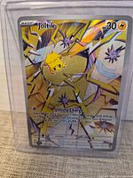 Front view of sleeved Joltik Rainbow Secret Rare card