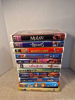 Stack of all 11 VHS tapes showing titles on spines