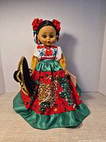 Front view of doll with sombrero and sequined skirt