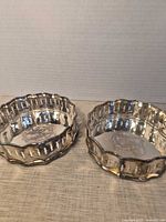 Both silver-plated coasters showing pierced rims and monogram centres