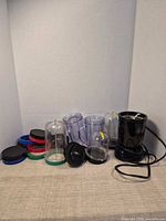 Overall lot showing blender base, cups, lids and blades