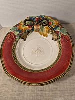Front view of porcelain charger showing full design and red rim