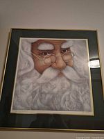 Full view of framed Santa print with gold frame and double mat