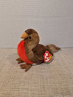 Left profile of Ty Early robin plush standing upright