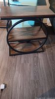 Front angled view showing overall design with circular metal frame, top and middle shelf