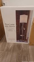 Factory box showing product image and labeling for Threshold floor lamp with shelves