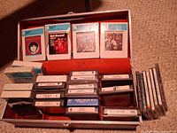 Open storage case showing all 8-track tapes, CDs and case interior