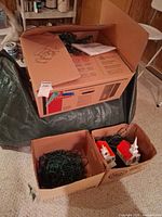 Boxes containing tree parts, stand, extra lights and village pieces