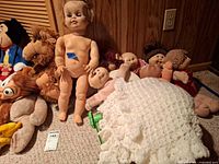 group view of all dolls, plush and blanket on floor
