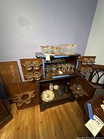 Bar cabinet open showing glassware on upper and lower sections