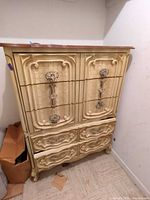 Front view of French Provincial highboy chest showing drawer configuration and ornate pulls