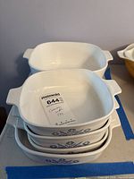 Stack of four CorningWare Cornflower P-1-B casseroles with lot tag visible