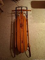 Full view of vintage Flexible Flyer wooden sled showing runners and steering crossbar