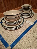 Two stacks of dinnerware pieces showing pattern, quantity and condition