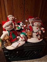 Group shot of all Hallmark plush snowmen on crate