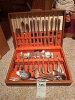 Open case showing full 36-piece flatware set in felt-lined wooden box