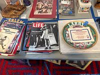 Plate box, stacks of vintage magazines on table