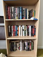 Full view of three-shelf bookcase showing quantity and mix of hardcover and paperback books