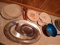 Group view of mixed dinnerware, silverplate tray and bowl, wooden servers, plates, blue bowl
