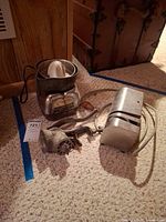 Juicer, meat grinder, electric knife sharpener grouped on floor