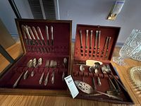 Two fitted wooden cases open showing entire flatware assortment