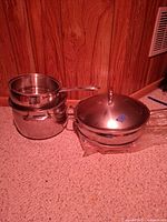 Stockpot with inserted saucepan/steamer and large domed lid visible