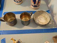 Top view of two cups and porringer showing interiors and tarnish