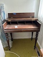 Full view of closed desk showing drop-front panel and turned legs