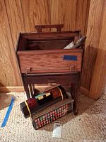Front view of wooden sewing box on stand with Legend device and box below