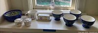 All nine pieces lined on shelf below window