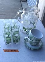 Group shot showing pitcher, five glasses, two cups stacked and two saucers