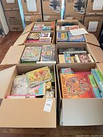 Six open cartons filled with assorted jigsaw puzzle boxes