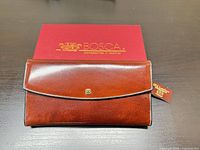 Closed Bosca leather wallet front with logo and product card