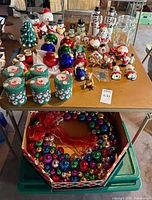 Overview of table with assorted Christmas decor and storage bin below