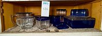 Cabinet view of all cobalt and clear glass refrigerator dishes and pitchers