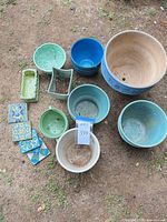 Group shot of assorted planters and tiles laid out on ground