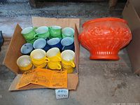 Orange milk glass punch bowl with box of multicolour cups
