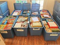 Eight blue storage tubs filled with numerous vintage puzzle boxes and bags