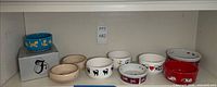 Shelf view of assorted cat-themed bowls