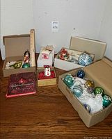 Overview of multiple ornament boxes, figurine ornament, ruler for scale, book visible