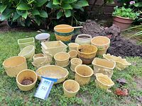 Group shot of all pastel yellow ceramic planters displayed on grass