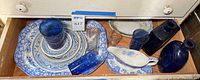 Drawer view showing Spode Blue Room platter, stack of plates, gravy boat, cobalt bottles and glasses