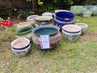 Group view of 11 ceramic planters upright on lawn