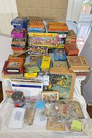 Overall lot showing stacked vintage puzzle boxes on table