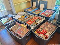 Nine large totes filled with assorted boxed and tin puzzles, inventory sheets visible