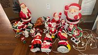 Group shot of all blow-mold and ceramic Santa figures with cords visible
