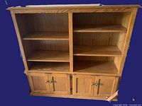 front view of oak-finish entertainment unit with shelves and lower cabinets