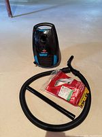 Vacuum body, hose, wand, and filter bag pack shown together