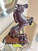 full view of carved wooden horse on base